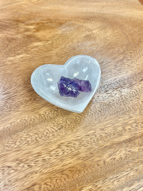 A single crystal resting in the Selenite Heart Bowl, highlighting its use for charging and cleansing.