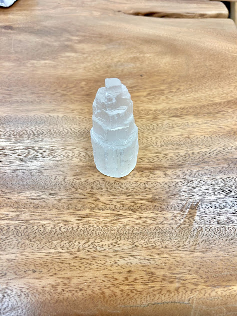 Elegant Selenite Small Tower standing on a wooden table, emitting a serene ambiance