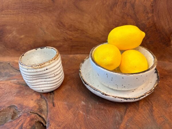 Kuta Waves Set on a wooden surface, the cup and bowl filled with bright lemons