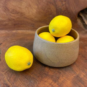 Legian Luxe Bowl with a rustic charm, filled with vibrant lemons on a wooden surface